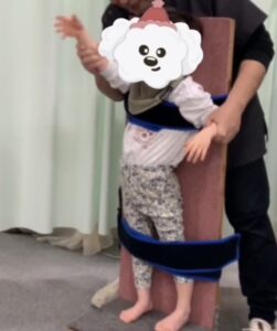 立位ボードでご挨拶! 先天性サイトメガロウイルス感染症で立てない女の子が、立位保持ボードの乗り立って手を振ってくれている
